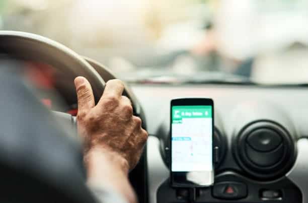 Closeup shot of a man using a phone to find directions while driving